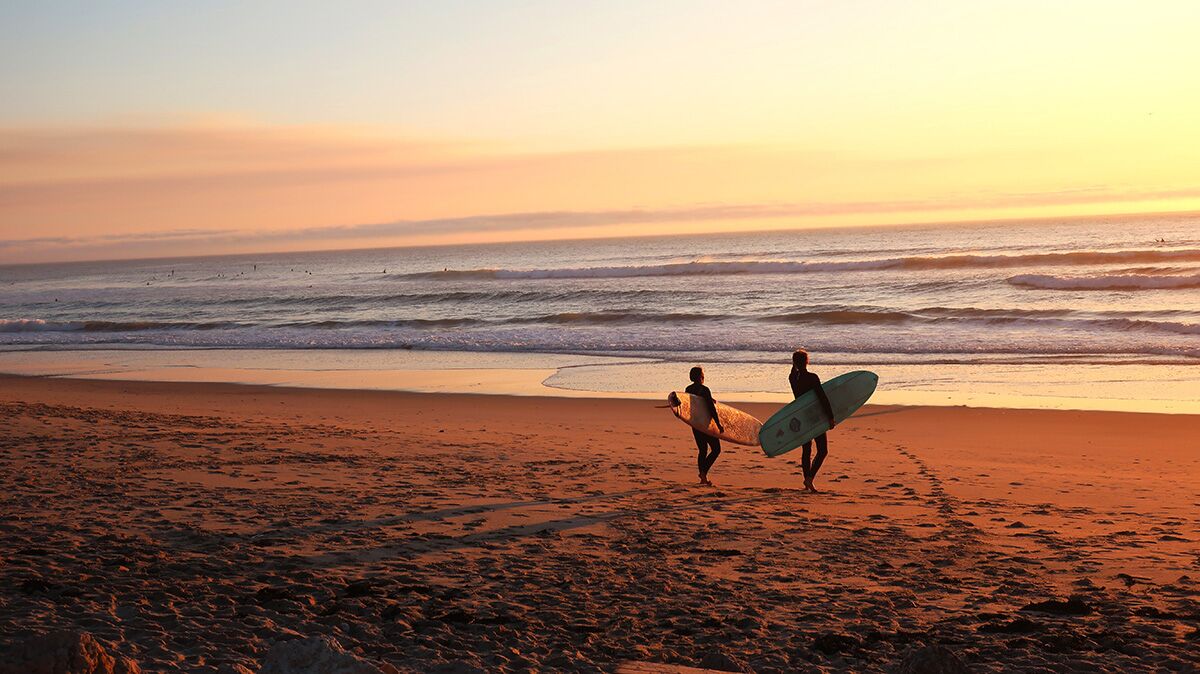 5-reasons-to-quit-the-big-city-and-move-to-the-spanish-coast-2 Surfers walking down the beach